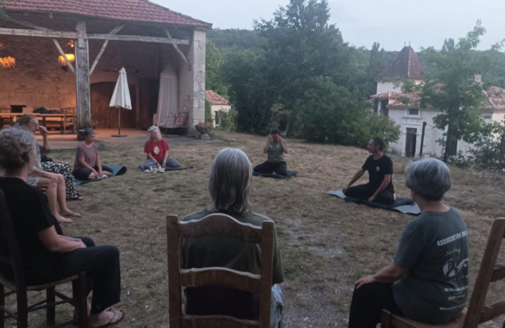 Vue d'ensemble du groupe en méditation en extérieur en fin de journée